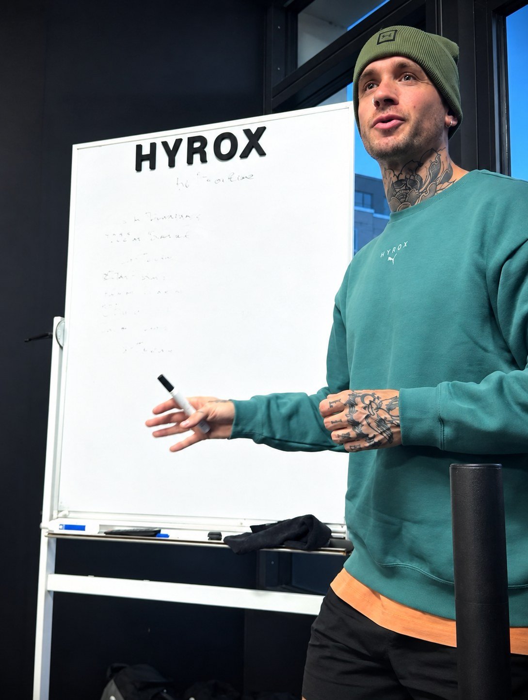 Luis explicando junto a una pizarra de HYROX